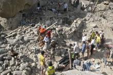 People gather on the rubble of houses destroyed by Saudi-led air strikes in Yemen's central city of Taiz August 21, 2015. Iranian-allied fighters controlling much of Yemen said on Friday air strikes led by Saudi Arabia killed 43 people in the central city of Taiz. PHOTO BY REUTERS/Stringer