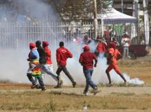 People flee teargas as opposition party supporters clash with police in Harare, Zimbabwe, August 26,2016. PHOTO BY REUTERS/Philimon Bulawayo