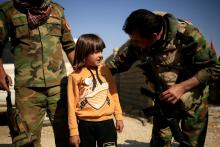 Kurdish Peshmerga soldiers, stationed between two front lines, talk to a child who just fled Abu Jarbuah village, near Bashiqa, east of Mosul, Iraq, October 29, 2016. PHOTO BY REUTERS/Zohra Bensemra