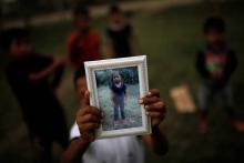 Abdel Caal, brother of Jakelin Caal, holds a picture of his sister outside their home in San Antonio Secortez village in Guatemala, December 22, 2018. PHOTO BY REUTERS/Carlos Barria