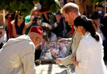 Britain's Prince Harry and Meghan, Duchess of Sussex, receive a picture from a market vendor during their visit to the Andalusian Gardens in Rabat, Morocco, February 25, 2019. PHOTO BY REUTERS/Youssef Boudlal