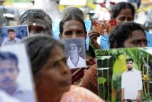 Sri Lankan Tamils hold pictures of family members who disappeared during the war against the Liberation Tigers of Tamil Eelam (LTTE) at a protest in Jaffna, about 400 km (250 miles) north of Colombo, November 15, 2013.  PHOTO BY REUTERS/Stringer