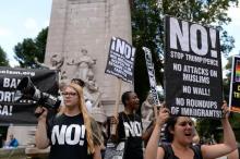 Activists hold placards as they protest against the U.S. Supreme Court decision to revive parts of a travel ban on people from six Muslim-majority countries in Columbus Circle, Manhattan, New York, U.S., June 26, 2017. PHOTO BY REUTERS/Amr Alfiky