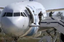 Unidentified people leave the hijacked Egyptair Airbus A320 at Larnaca Airport in Larnaca, Cyprus, March 29, 2016. PHOTO BY REUTERS/Yiannis Kourtoglou