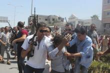 Police officers control the crowd (rear) while surrounding a man (front C) suspected to be involved in opening fire on a beachside hotel in Sousse, Tunisia, as a woman reacts(R), June 26, 2015. PHOTO BY REUTERS/Amine Ben Aziza