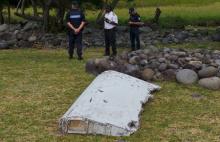 French gendarmes and police stand near a large piece of plane debris which was found on the beach in Saint-Andre, on the French Indian Ocean island of La Reunion, July 29, 2015. PHOTO BY REUTERS/Prisca Bigot