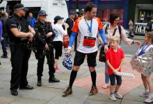 Armed police officers stand on duty as participants in a fun run walk past in central Manchester, Britain, May 28, 2017. PHOTO BY REUTERS/Phil Noble