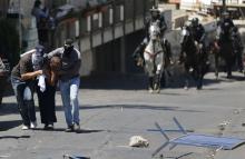 Undercover Israeli police officers detain a Palestinian suspected of throwing stones in the East Jerusalem neighbourhood Wadi al-Joz during a protest against the Israeli offensive on Gaza