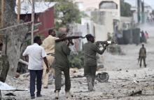 Somali police hold their weapons as they walk outside the Maka Al-Mukarama hotel during an Islamist group al Shabaab attack in the capital Mogadishu, March 27, 2015. PHOTO BY REUTERS/Feisal Omar