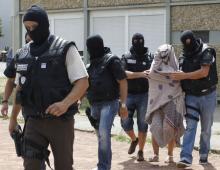 French special police forces escort a woman from a residential building during a raid in Saint-Priest, near Lyon, France, June 26, 2015. PHOTO BY REUTERS/Emmanuel Foudrot