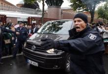 A policeman reacts as a vehicle carying released Al Jazeera's journalist Ahmed Mansour leaves Moabit court in Berlin, Germany, June 22, 2015. PHOTO BY REUTERS/Fabrizio Bensch