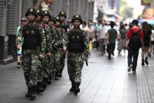Paramilitary policemen patrol along a street in Shenzhen, Guangdong province, May 27, 2014. PHOTO BY REUTERS/Stringer