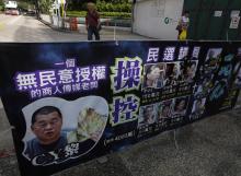 A poster mocking Jimmy Lai Chee-ying, chairman of Next Media, offering money to pro-democracy lawmakers, is displayed at Hong Kong's financial Central district