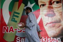 A man walks past an image of cricket star-turned-politician Imran Khan, chairman of Pakistan Tehreek-e-Insaf (PTI) at a market in Islamabad, Pakistan, July 27, 2018. PHOTO BY REUTERS/Athit Perawongmetha
