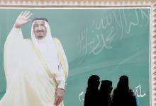  Women walk past a poster of Saudi Arabia's King Salman bin Abdulaziz Al Saud during Janadriyah Cultural Festival on the outskirts of Riyadh, Saudi Arabia, February 12, 2018. PHOTO BY REUTERS/Faisal Al Nasser