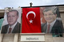 A special forces police officer takes security measures as he stands on top of a building where the portraits of Turkey's President Tayyip Erdogan (L), Prime Minister Ahmet Davutoglu and a Turkish flag are displayed in Istanbul, Turkey, June 3, 2015. PHOTO BY REUTERS/Murad Sezer