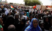 Sudanese protesters hold national flags and banners as they march outside the defense ministry compound in Khartoum, Sudan, April 29, 2019. PHOTO BY REUTERS/Umit Bektas