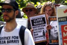 Protesters react as they hold placards and listen to speakers during a rally in support of refugees in central Sydney, Australia, October 19, 2015. PHOTO BY REUTERS/David Gray