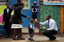 A school official takes a pupil's temperature using an infrared digital laser thermometer in front of the school premises, at the resumption of private schools, in Lagos, September 22, 2014. PHOTO BY  REUTERS/Akintunde Akinleye