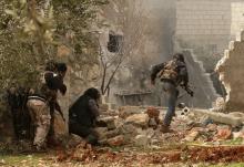 A rebel fighter carries his weapon as he runs while others take positions in Ratian village, north of Aleppo, after what the rebels said was an offensive against them by forces loyal to Syria's President Bashar al-Assad that attempted to advance in the village but failed to, February 18, 2015. PHOTO BY REUTERS/Ammar Abdullah