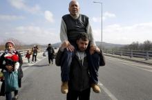 Stranded refugees walk through a motorway towards the Greek-Macedonian border near the Greek village of Idomeni as at least 20,000 refugees and migrants have been stranded in Greece after border shutdowns through the Balkans route to central and northern Europe, February 26, 2016. PHOTO BY REUTERS/Yannis Behrakis