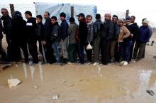 Syrian refugees wait to receive humanitarian aid at the Al Zaatri Syrian refugee camp in the Jordanian city of Mafraq, near the border with Syria, January 28, 2013. PHOTO BY REUTERS/Ali Jarekji