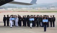 U.N. honor guards carry small boxes containing remains believed to be from American servicemen killed during the 1950-53 Korean War after they arrived from North Korea, at Osan Air Base in Pyeongtaek, South Korea, Friday, July 27, 2018. PHOTO BY REUTERS/Ahn Young-joon/Pool