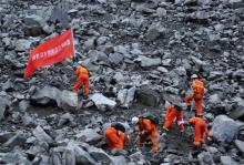 Rescue workers search for survivors at the site of a landslide that occurred in Xinmo Village, Mao County, Sichuan province, China June 24, 2017. The writing on the flag reads: "Chengdu Fire Departmant Rescue Team". PHOTO BY REUTERS/Stringer