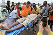 A rescued tourist is attended by rescue personnel after a boat he was travelling in capsized off the tourist island of Phuket, Thailand, July 6, 2018. PHOTO BY REUTERS/Sooppharoek Teepapan