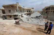 A man drives a motorcycle near a site hit by what residents said were airstrikes carried out by the Russian air force in the town of Darat Izza, in Aleppo province, Syria, October 13, 2015. PHOTO BY REUTERS/Ammar Abdullah