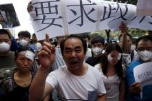 Residents evacuated from their homes after last week's explosions at Binhai new district, take part in a rally demanding government compensation outside the venue of the government officials' news conference in Tianjin, China, August 17, 2015. PHOTO BY REUTERS/Kim Kyung-Hoon