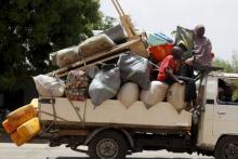 People travel in a truck with their belongings as they return after the Nigerian military recaptures the town of Michika from Boko Haram, Adamawa state, May 10, 2015. PHOTO BY REUTERS/Akintunde Akinleye