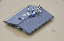 An aerial view shows local residents seen on the roof of submerged house at a flooded area as they wait for a rescue in Kurashiki, southern Japan, in this photo taken by Kyodo July 7, 2018. PHOTO BY REUTERS