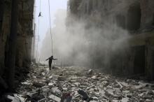 A man walks on the rubble of damaged buildings after an airstrike on the rebel held al-Qaterji neighbourhood of Aleppo, Syria, September 25, 2016. PHOTO BY REUTERS/Abdalrhman Ismail