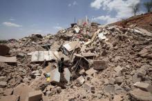 A Houthi militant stands amidst debris from a house of a Houthi leader Rafiq Rafiq, which was destroyed by a Saudi-led air strike, near Sanaa, May 30, 2015. PHOTO BY REUTERS/Mohamed al-Sayaghi