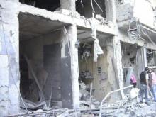 People look at damaged buildings at Al-Zabadani, August 8, 2012. PHOTO BY REUTERS/Shaam News Network