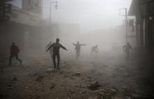 Civil defence members and civilians are seen running after an air raid in the besieged town of Douma in eastern Ghouta in Damascus, Syria, February 6, 2018. PHOTO BY REUTERS/Bassam Khabieh