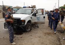 Iraqi security forces inspect the site of a suicide bombing outside a polling station in Kirkuk