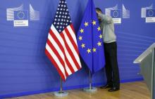 A worker adjusts European Union and U.S. flags at the start of the 2nd round of EU-US trade negotiations for Transatlantic Trade and Investment Partnership at the EU Commission headquarters in Brussels, November 11, 2013. PHOTO BY REUTERS/Francois Lenoir