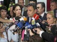 Brazilian Senator Aecio Neves (C) speaks to the media next to Lilian Tintori (R), wife of opposition leader Leopoldo Lopez, Patricia Ceballos (back L), mayor of San Cristobal and wife of jailed former mayor Daniel Ceballos, and opposition leader Maria Corina Machado (2nd L), at the Simon Bolivar airport in Caracas, June 18, 2015. PHOTO BY REUTERS