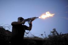 A serviceman of the Ukrainian armed forces fires a weapon in the direction of positions of units of the armed forces of the self-proclaimed Donetsk People's Republic during a battle in Avdiivka, Donetsk region, Ukraine, August 23, 2015. PHOTO BY REUTERS/Maksim Levin