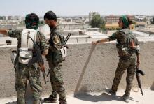 Sheen Ibrahim, Kurdish fighter from the People's Protection Units (YPG) stand on a roof top together with other YPG fighters in Raqqa, Syria, June 16, 2017. PHOTO BY REUTERS/Goran Tomasevic