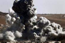 Smoke and dust rise over Syrian town of Kobani after an airstrike, as seen from the Mursitpinar crossing on the Turkish-Syrian border in the southeastern town of Suruc in Sanliurfa province October 22, 2014. PHOTO BY REUTERS/Kai Pfaffenbach