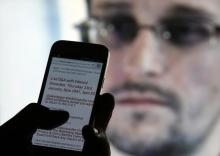 A man uses his cell phone to read updates about former U.S. spy agency contractor Edward Snowden answering users' questions on Twitter in this photo illustration, in Sarajevo