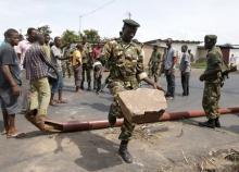 A soldier drops a stone while removing a barricade which was set up by protesters in Bujumbura, Burundi, May 16, 2015. PHOTO BY REUTERS/Goran Tomasevic