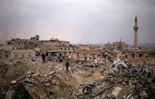 A member of forces loyal to Syria's President Bashar al-Assad stands with a civilian on the rubble of the Carlton Hotel, in the government controlled area of Aleppo, Syria. PHOTO BY REUTERS/Omar Sanadiki