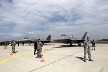 U.S. Army soldiers guard as U.S. Air Force F-22 Raptor fighters are parked in the military air base in Siauliai, Lithuania, April 27, 2016. PHOTO BY REUTERS/Ints Kalnins