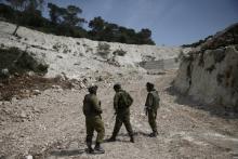 Israeli soldiers observe the area where the Israeli army is excavating part of a cliff to create an additional barrier along its border with Lebanon, near the community of Shlomi in northern Israel, April 6, 2016. PHOTO BY REUTERS/Ronen Zvulun