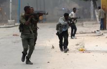 Somali government soldiers run to take their positions during gunfire after a suicide bomb attack outside Nasahablood hotel in Somalia's capital Mogadishu, June 25, 2016. PHOTO BY REUTERS/Feisal Omar