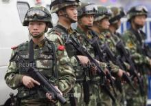 Armed paramilitary policemen stand guard in front of the Guangzhou Railway Station after a knife attack, in Guangzhou, Guangdong province, March 6, 2015. PHOTO BY REUTERS/Alex Lee